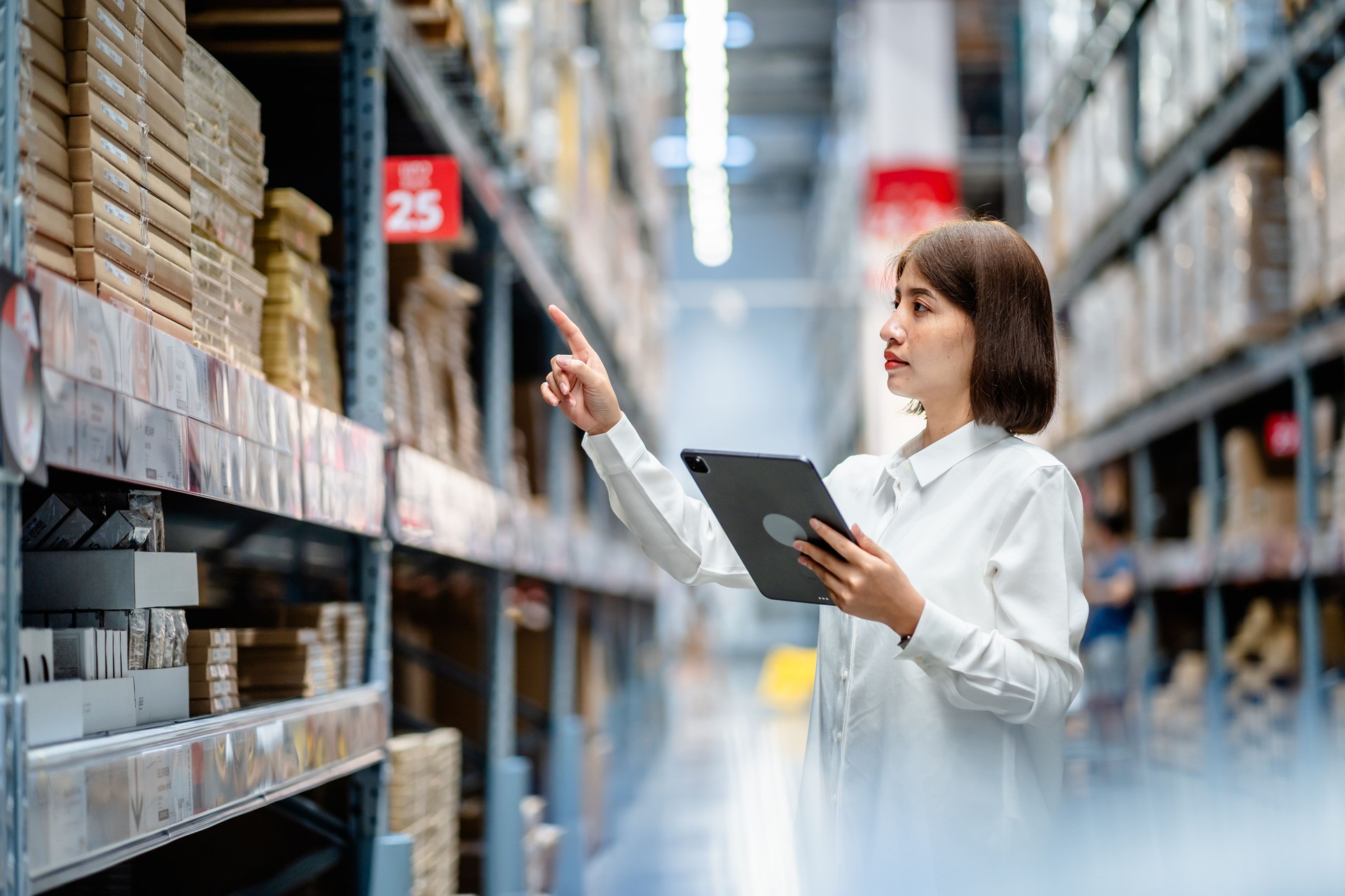 Women warehouse worker using digital tablets to check the stock inventory on shelves in large warehouses, a Smart warehouse management system, supply chain and logistic network technology concept